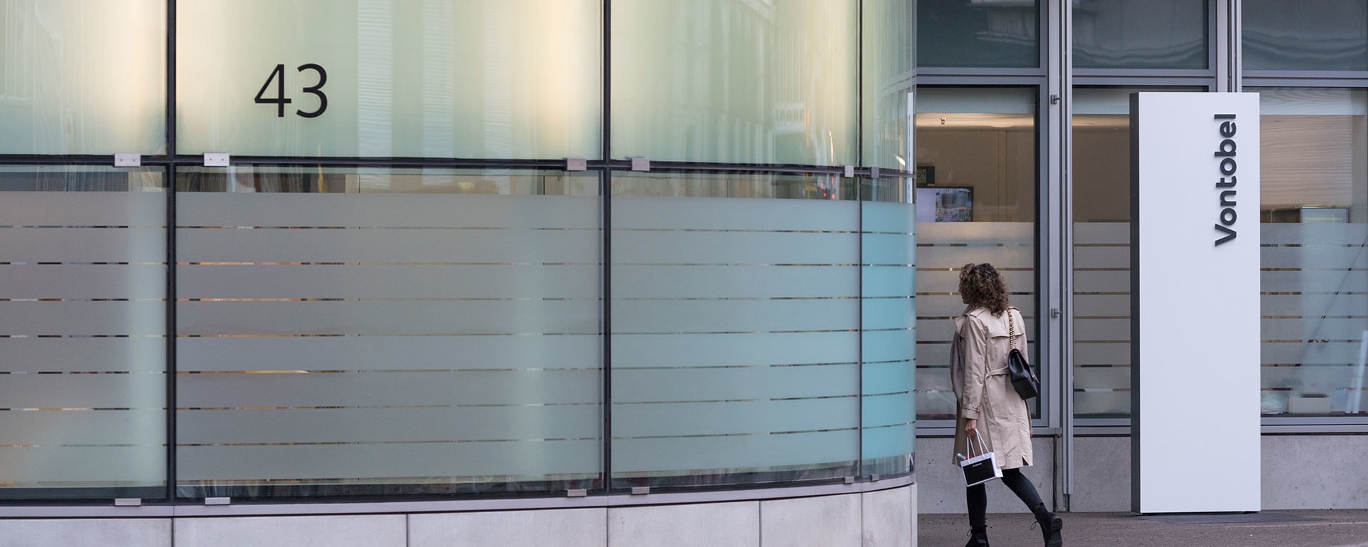 About Vontobel - A woman walking into Vontobel's main building