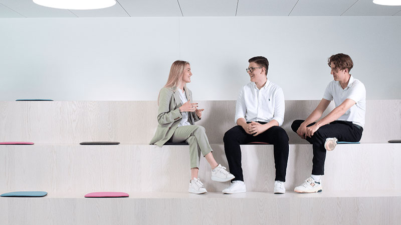 Three apprentices having a conversation on a tribune.