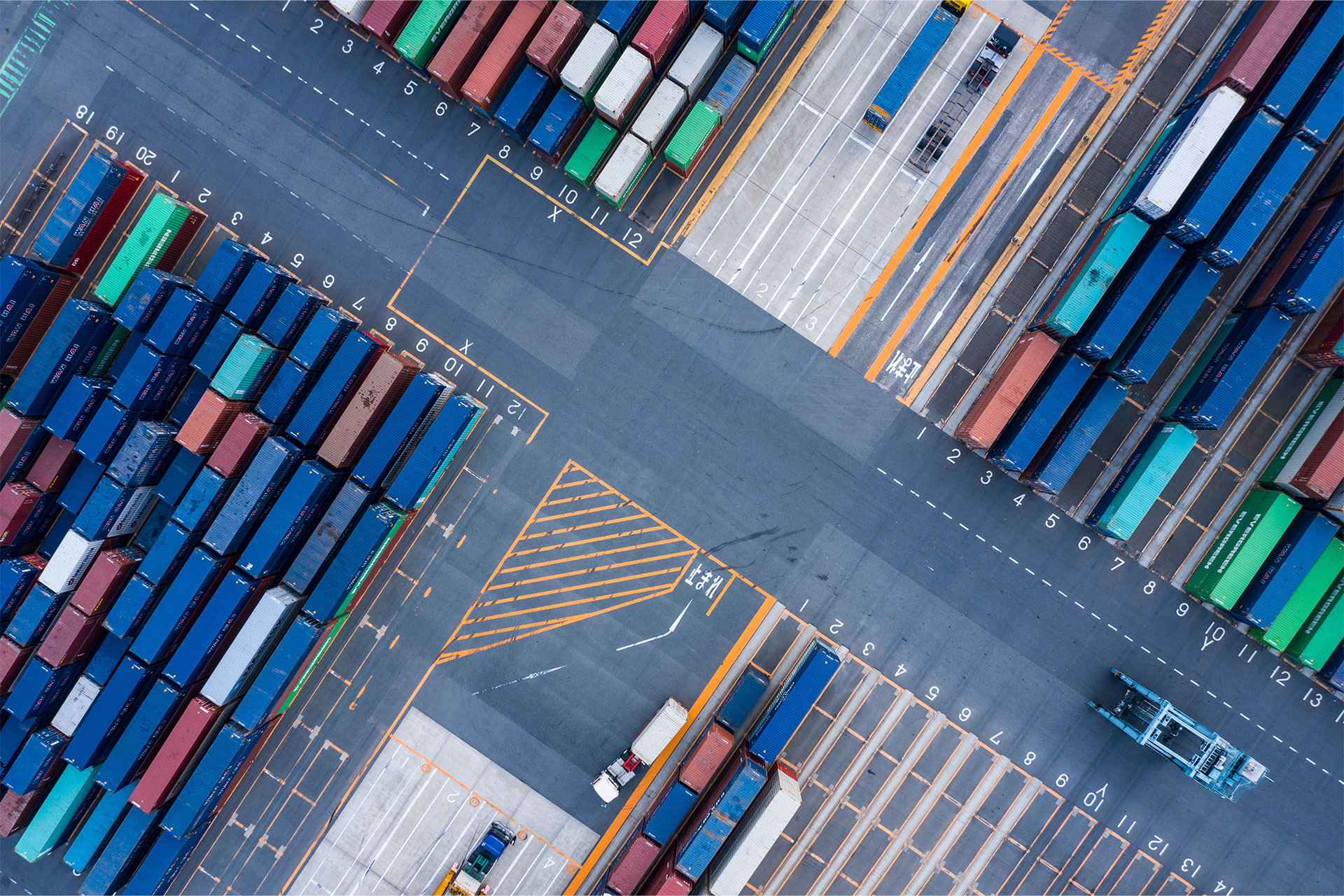Bird's eye view of several colorful, large shipping containers parked side by side.