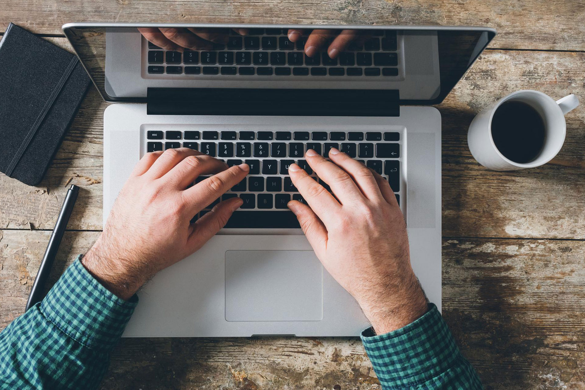 A man typing on the keyboard of his laptop and filling out the contact form for data protection.